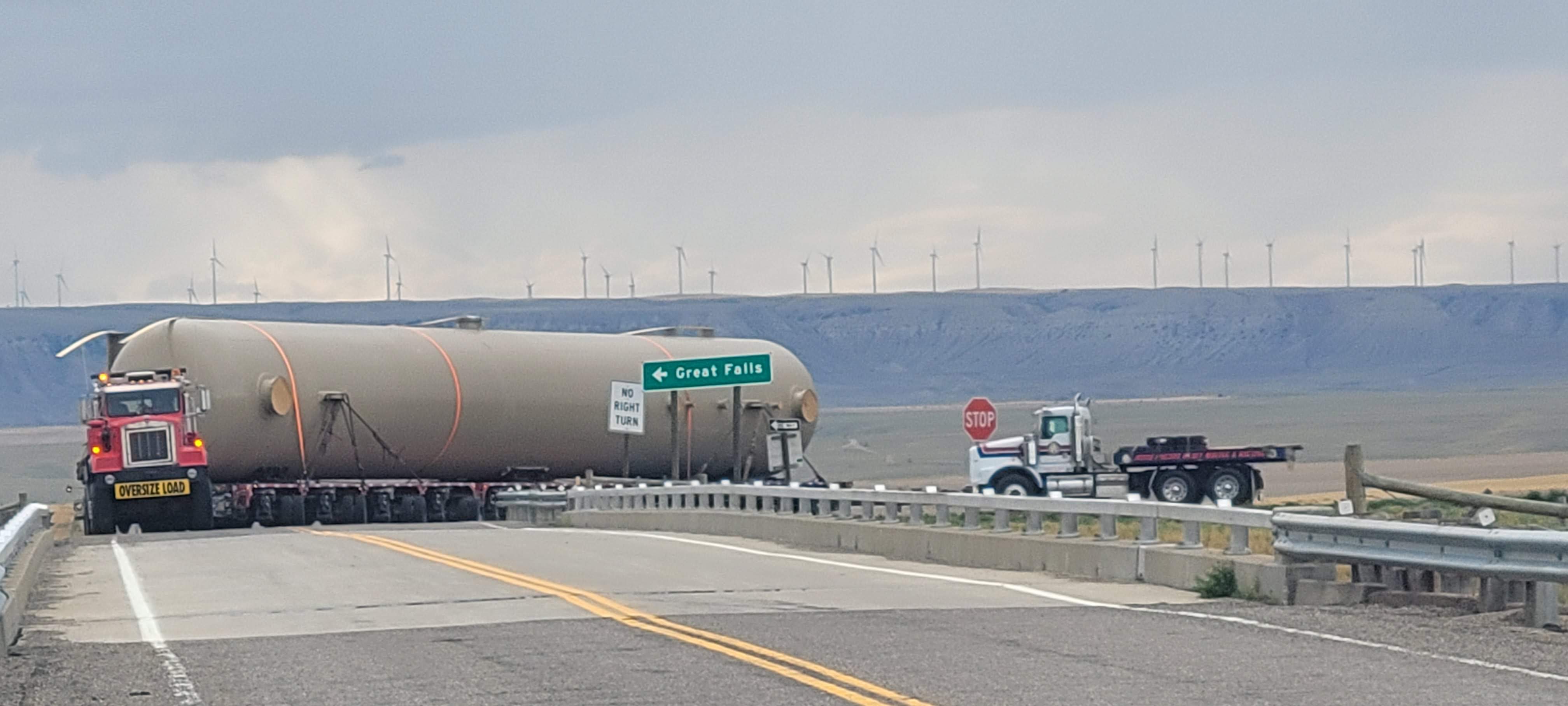 Big truck with flatbed trailer hauling plastic pipe.